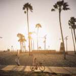 Biker and skateboarder in Venice Beach, Los Angeles, California at sunset
