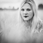 Porträt einer jungen blonden Frau in einem Getreidefeld